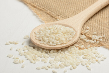 Arroz redondo en un bol blanco de cocina en la mesa blanca