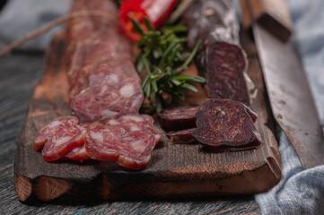 raw sausage with chili peppers and rosemary. on a wooden board and laces