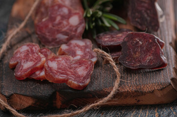 raw sausage with chili peppers and rosemary. on a wooden board and laces