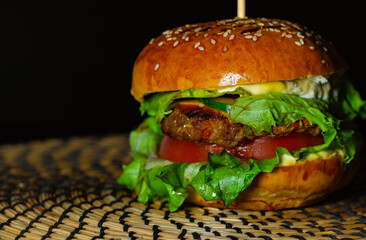 juicy tasty meat burger with cheese, herbs and vegetables, ready to eat