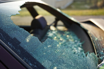 Broken rear window in car during accident or theft with pieces of glass, thief smashed window and...