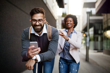 Young couple on vacation having fun driving electric scooter in the city.