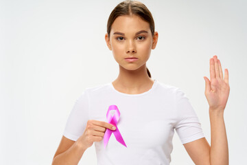 Female volunteer with pink ribbon against cancer tumor