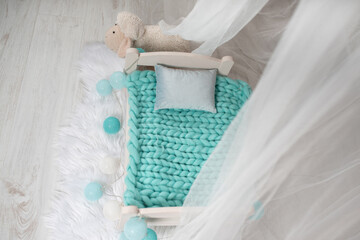 Fototapeta na wymiar Newborn baby bed with a little sheep in a photo studio