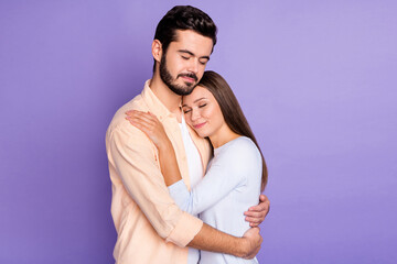 Photo of charming married couple hug closed eyed wear casual clothes isolated on purple color background