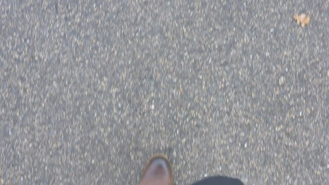 The look of man walking on the peebled ground with his brown color shoes in Estonia