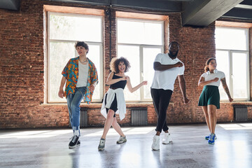 Happy young people dancing together in sport hall