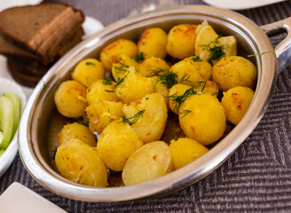 toasted young potatoes with dill in metal skillet