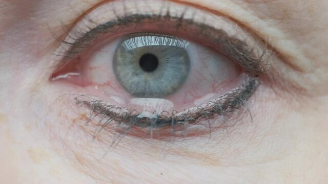 drop of tears flowing down cheek from eye crying woman closeup.