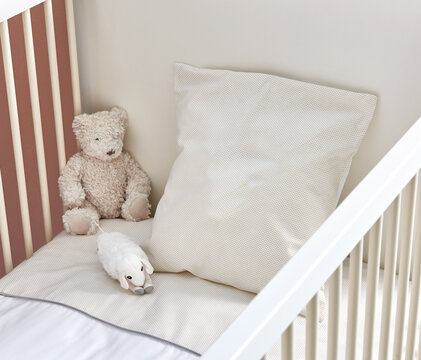 Baby room concept with pillow and bear, inside the bed style.