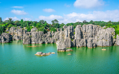 Limestone rock formation over beautiful lake and blue sky at Shilin stone forest park Yunnan China