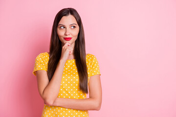 Photo of attractive thoughtful young woman look empty space hold hand chin isolated on pink color...