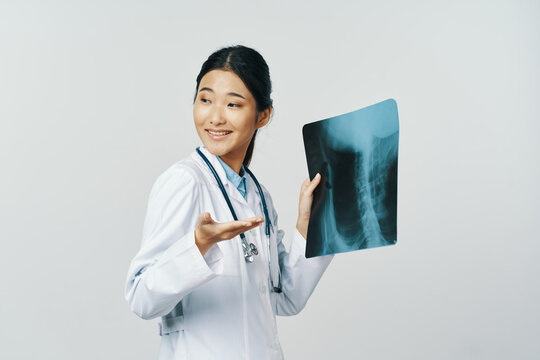 Professional woman doctor in a medical coat holds an x-ray in his hand 