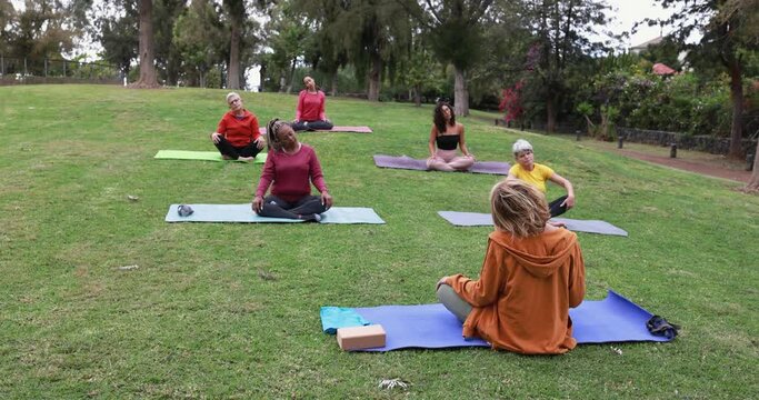People doing yoga class keeping social distance at city park - Healthy lifestyle and sport during coronavirus outbreak