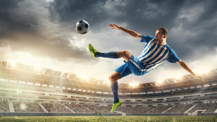 Male football or soccer player at stadium in flashlight. Young male sportive model training. Moment of attacking, catching. Concept of sport, competition, winning, action, motion, overcoming. Flyer.