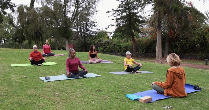 People doing yoga class keeping social distance at city park - Healthy lifestyle and sport during coronavirus outbreak