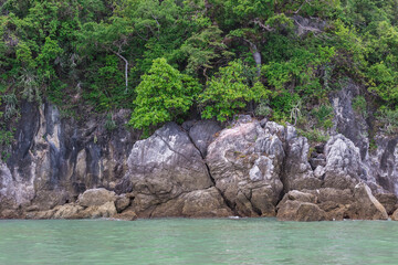 A picture of the sea with granite cliff mountain, it is one type of rock which forms from magma as a beautiful natural theme.