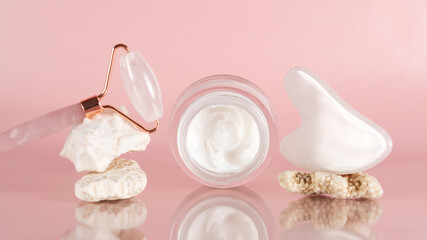 Face cream, gouache scraper and jade massage roller for face massage. Home facial skin care. 