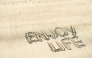 enjoy life hanschriftlich in den Sand geschrieben 