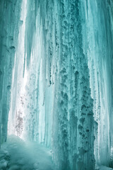 Big blue frozen icicles. Icefall. Frozen waterfall.