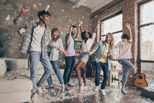 Full length photo of funky happy people dance festive event confetti fly indoors inside house apartment