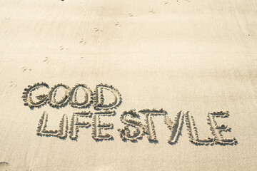 Fototapeta na wymiar good lifestyle im Sand geschrieben handschriftlich
