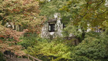 The beautiful old Chinese garden view with the black tiles roof and stone sculpture decoration
