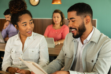 african american woman collaborating and discussing project plans in office workspace. .