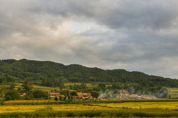 Fototapeta premium Villages and fields under dark clouds in autumn