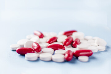 Heap of red and white medicines on blue background
