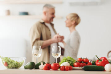 Romantic beautiful couple in modern cozy white kitchen room interior, celebrate holiday together at home