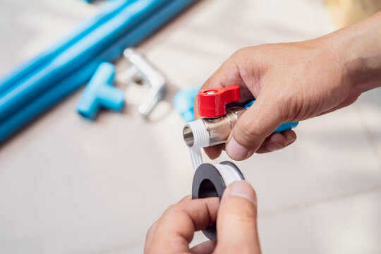 plumber putting teflon thread tape on the thread , Preparing to connect to PVC Pipe at home