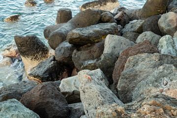 Steinküste Gran Canaria bei Sonnenaufgang und ruhiger See mit leichtem Wellengang