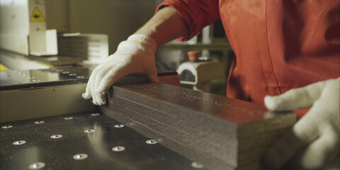 Unrecognisable workers in gloves carry wood planks puts it in piles at sawmill, slow motion close up
