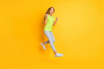 Fototapeta na wymiar Full length profile side photo of young cheerful girl happy smile rejoice victory jump up isolated over yellow color background