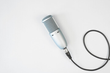 Professional studio condenser microphone on a light background, top view. Audio broadcasting, podcast concept.
