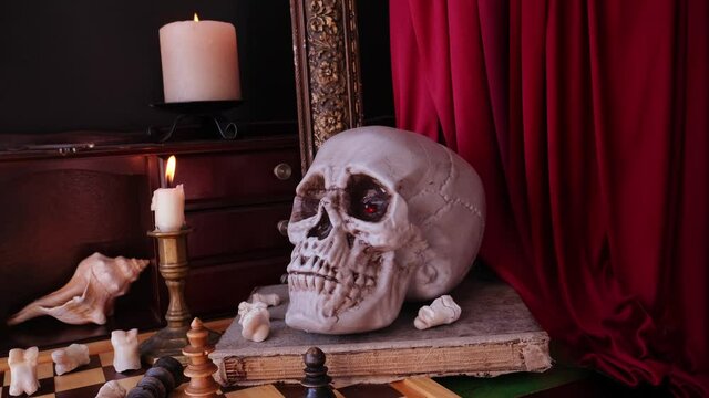 allegorical still life in the genre of baroque Vanitas, a skull on a book, candles are burning, the concept of the transience of life, the futility of pleasures and the inevitability of death