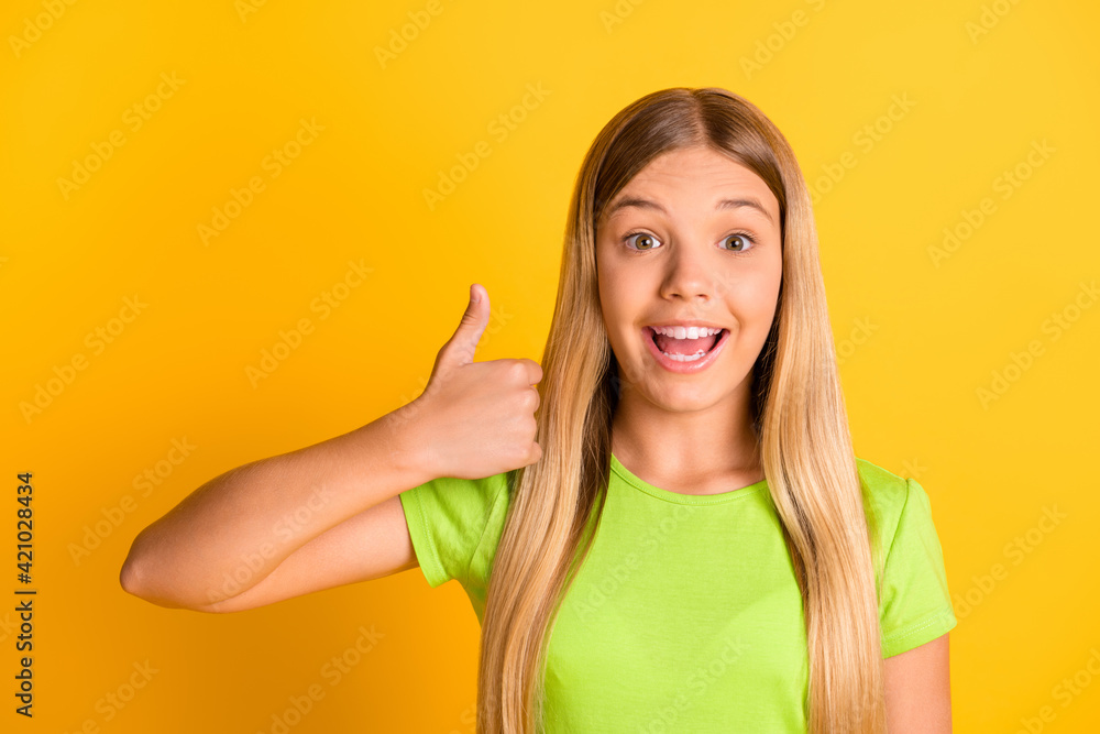 Sticker Photo of young excited preteen girl happy smile show thumb-up like cool advert fine perfect isolated over yellow color background