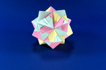Self-made colorful origami star cube with blue background.