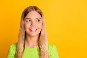 Photo of young attractive preteen girl happy positive smile dream dreamy look empty space isolated over yellow color background
