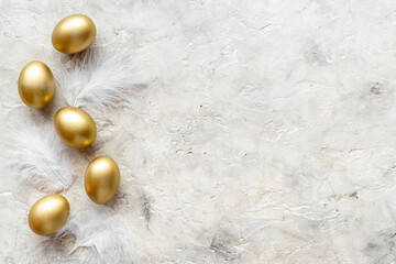 Golden Easter eggs with white feather. Easter decoration, top view