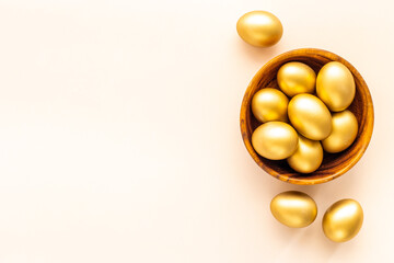 Golden eggs in wooden bowl. Wealth and good luck concept. Easter decoration