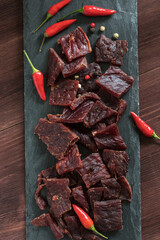 spice beef jerky on black shale board
