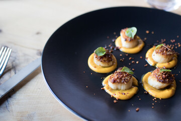 Seared scallops seafood puree pumpkin black plate dinner restaurant fine dining elegant meal food