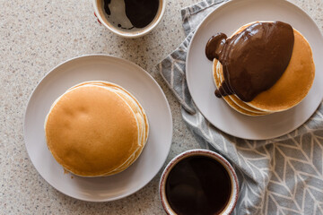 two plates with stacks of pancakes