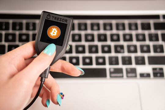 The woman holds in her hand her hardware crypto wallet TREZOR MODEL T.