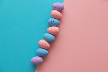 Minimal Easter concept. Multi-colored eggs on a blue and pink background. View from above. Flat lay, copy space