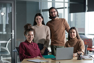 Portrait of successful business team smiling at camera while working in team together at office