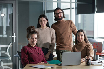 Obraz na płótnie Canvas Portrait of successful business team smiling at camera while working in team together at office