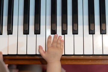 Baby Girl's Right Hand Playing with Piano Keys